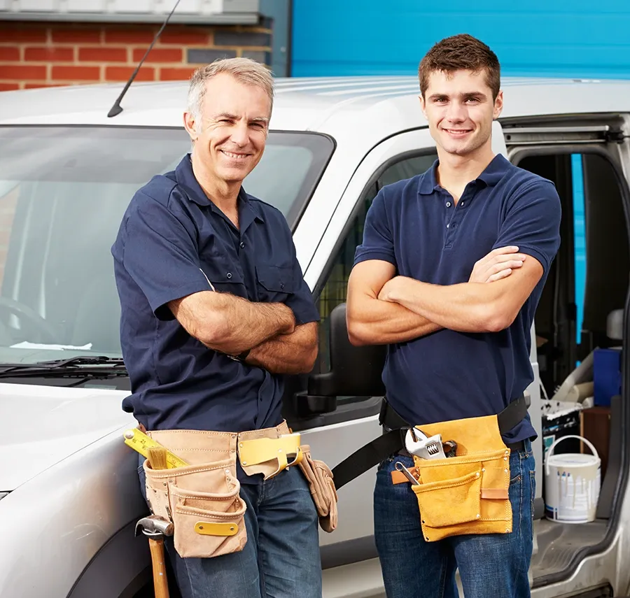 Two electricians stand in front of their work truck.